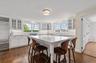 Kitchen with glass insert cabinets, tasteful backsplash, and white cabinets