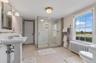 Full bathroom featuring radiator heating unit, a stall shower, and plenty of natural light