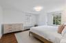 Bedroom with dark wood-style floors and radiator heating unit