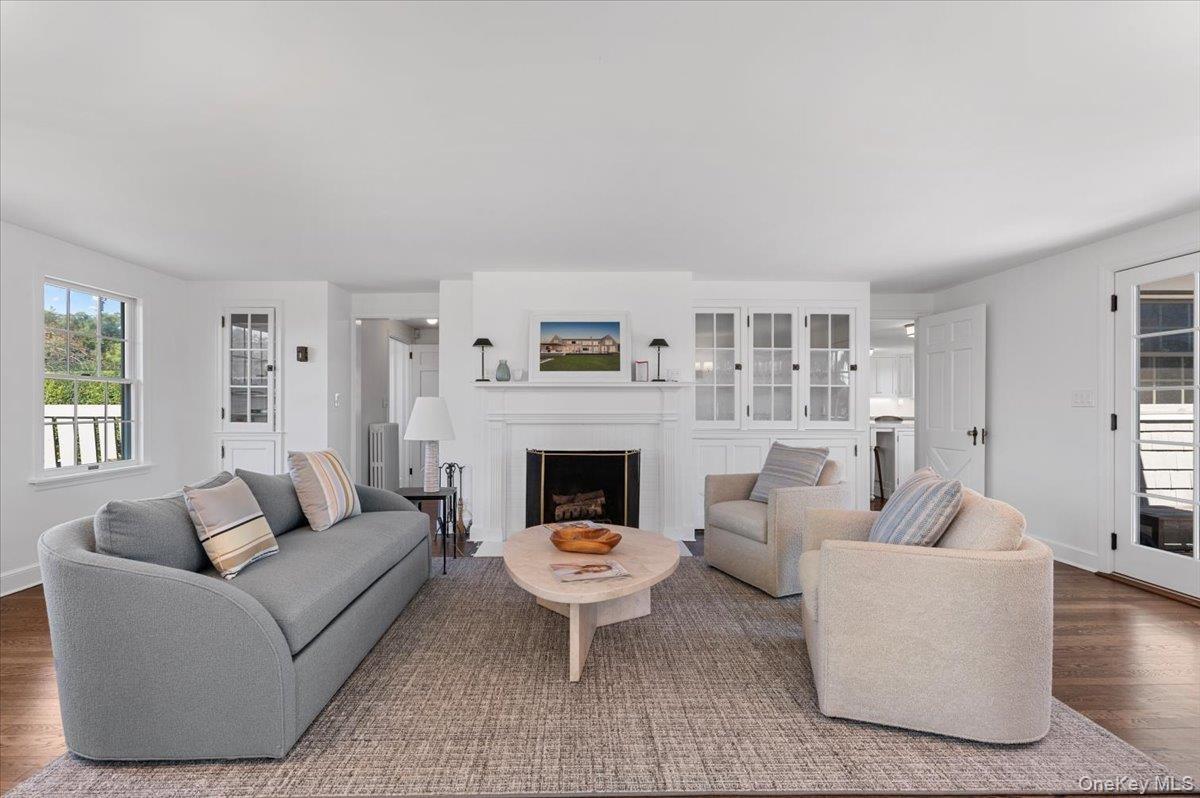 Living room with healthy amount of natural light, wood finished floors, and a fireplace