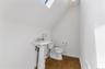 Half bath featuring a skylight, lofted ceiling, and dark wood-style flooring