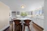 Kitchen featuring white cabinets, a kitchen breakfast bar, built in refrigerator, and backsplash
