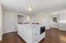 Kitchen featuring white cabinets, a breakfast bar area, dark wood-style floors, and tasteful backsplash