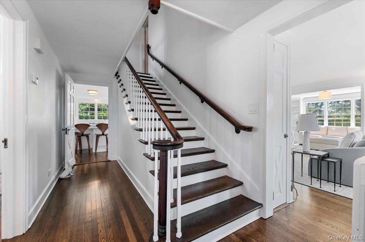 Stairway with wood-type flooring and plenty of natural light