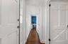 Hall featuring dark wood-type flooring and baseboards