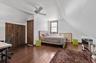Bedroom featuring vaulted ceiling, dark wood-type flooring, an office area, a ceiling fan, and a closet