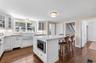 Kitchen with white cabinetry, backsplash, a kitchen bar, and glass insert cabinets
