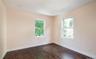 Spare room with dark wood-style floors and plenty of natural light
