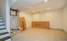 Finished basement featuring stairway, recessed lighting, light tile patterned flooring, concrete block wall, and heating unit