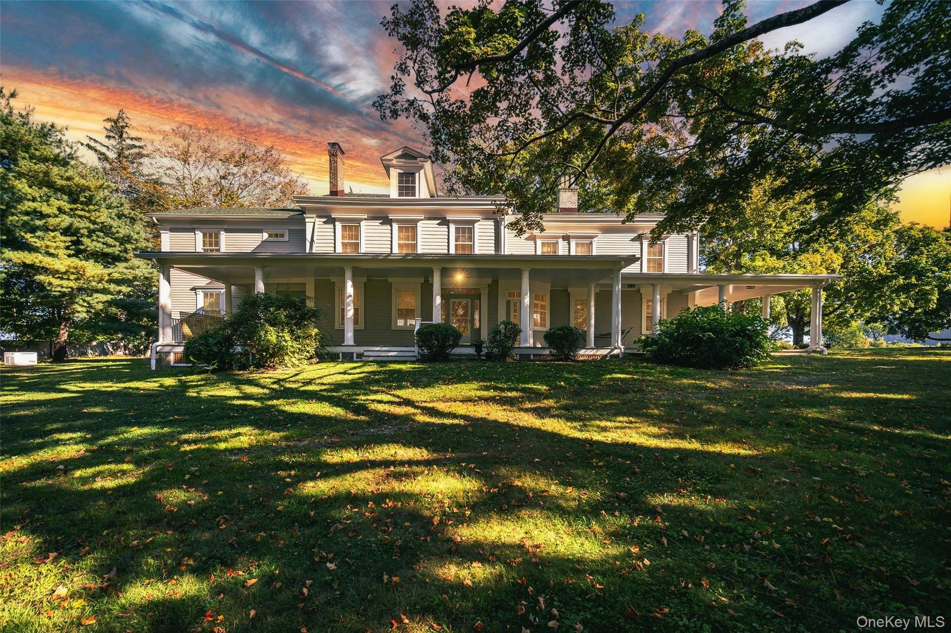 View of front of home featuring a porch, a chimney, and a lawn