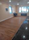 Living room with crown molding, dark wood-type flooring, and radiator heating unit