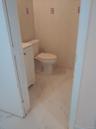Half bathroom with tile walls, light marble finish flooring, and vanity