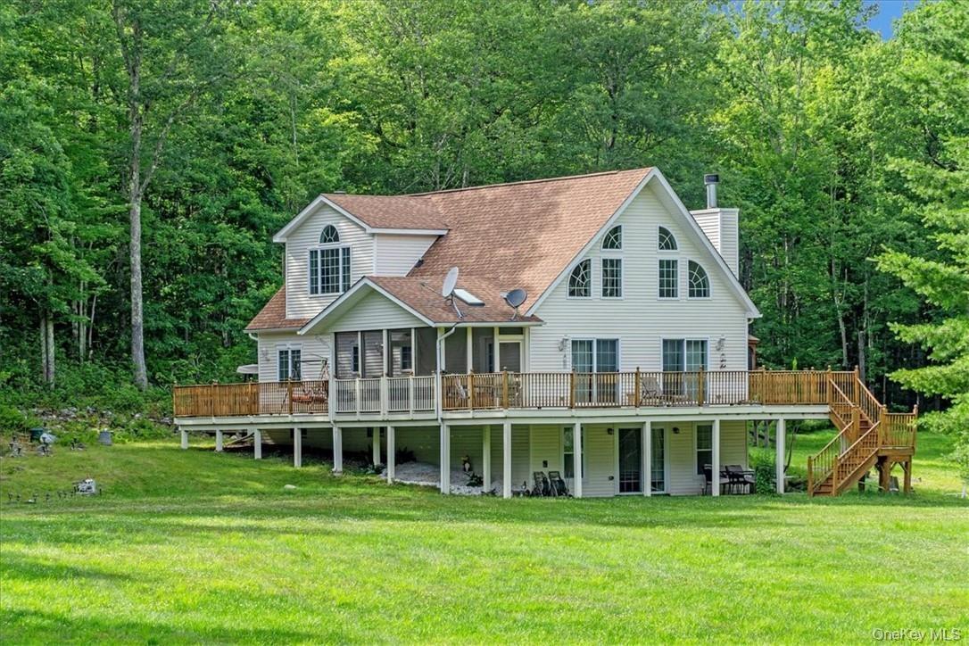 Rear view of property with a yard and a wooden deck