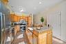 Kitchen with appliances with stainless steel finishes, light tile patterned floors, sink, and a kitchen island