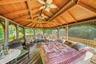 Sunroom featuring vaulted ceiling with beams, wood ceiling, and ceiling fan