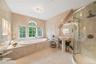 Bathroom with tile patterned flooring, tile walls, shower with separate bathtub, and sink