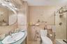 Bathroom featuring sink, an enclosed shower, tile walls, and toilet