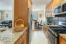 Kitchen featuring stainless steel appliances, a sink, tasteful backsplash, ornamental molding, and light stone countertops