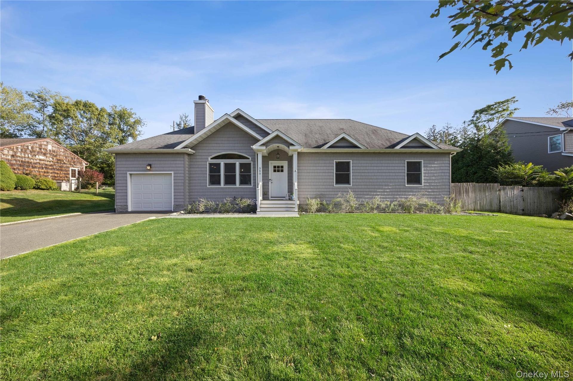 Single story home featuring concrete driveway, a chimney, a shingled roof, and a garage