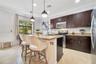 Modern kitchen with granite counters, stainless steel appliances, and rich wood cabinetry. Bright breakfast nook by the window offers a cozy dining sp