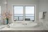 Bathroom with a bathtub and a water view