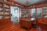 Office featuring a chandelier, dark wood-type flooring, and a fireplace