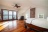 Bedroom with ceiling fan, access to outside, wood-type flooring, vaulted ceiling, and a water view