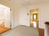 Hallway with wood finished floors and a wainscoted wall