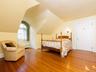 Bedroom with hardwood / wood-style flooring, radiator heating unit, and vaulted ceiling