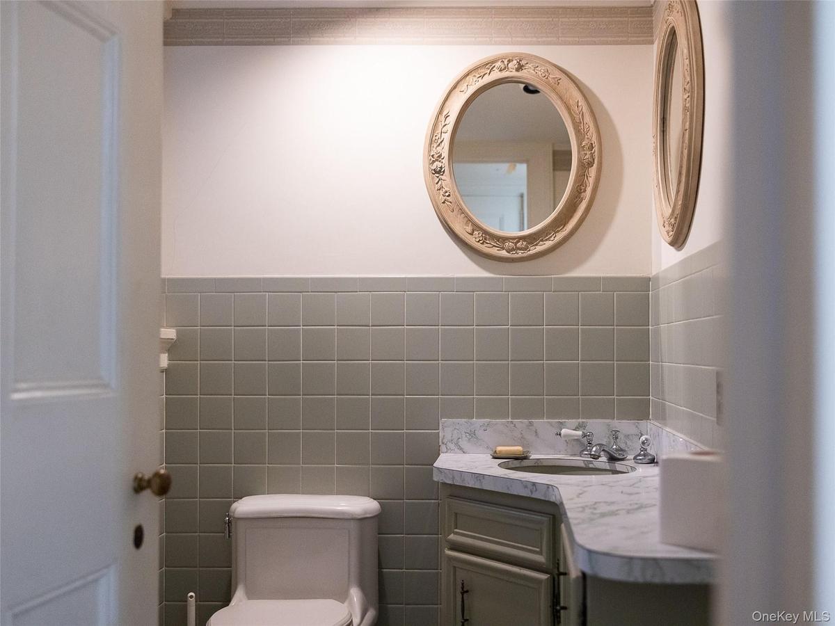 Bathroom with tile walls, vanity, and wainscoting