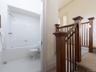 Full bathroom with tiled shower / bath combo and light tile patterned floors