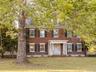 Georgian-style home featuring brick siding, a front lawn, and crawl space