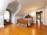 Bedroom featuring light wood finished floors, multiple windows, and vaulted ceiling