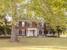 Colonial inspired home with brick siding, a front lawn, and crawl space