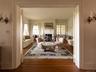 Living room with dark wood-type flooring, a fireplace, and ornamental molding