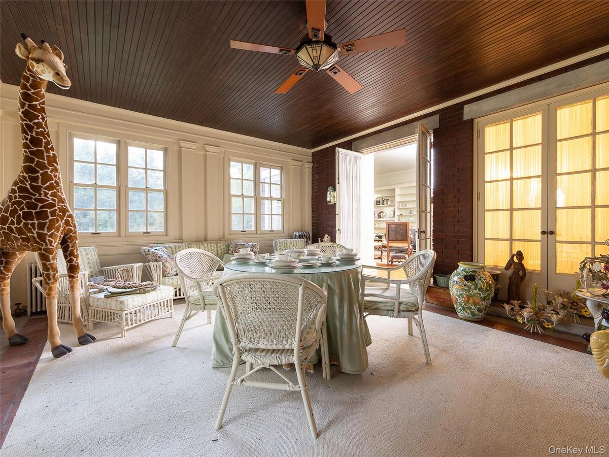 Dining area with ceiling fan and brick wall