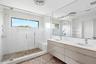Bathroom featuring a sink, a shower stall, and visible vents