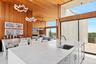 Kitchen with pendant lighting, wooden ceiling, a sink, wooden walls, and a towering ceiling