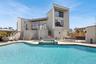 Rear view of property with stairway, a patio, an outdoor living space, and a pool with connected hot tub