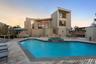 Back of property featuring outdoor lounge area, a pool with connected hot tub, a patio area, stairway, and a wooden deck