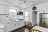 Kitchen with stainless steel appliances, tasteful backsplash, ceiling fan, light countertops, and white cabinetry