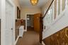 Foyer with a chandelier, carpet floors, and wood walls