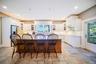 Kitchen with glass insert cabinets, a breakfast bar, white cabinets, and recessed lighting