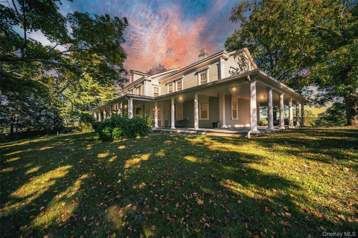 View of front of house featuring a porch, a chimney, and a front yard