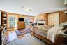 Bedroom with a fireplace, hardwood / wood-style flooring, and a wall mounted air conditioner