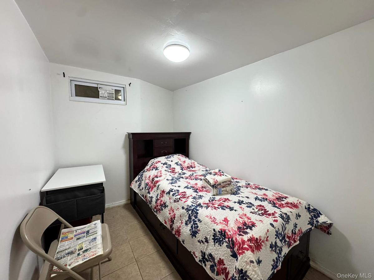 Bedroom with light tile patterned flooring and baseboards
