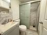 Bathroom featuring a marble finish shower, vanity, and marble finish floors