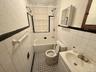 Bathroom featuring tile walls, a textured wall, bathtub / shower combination, vanity, and tile patterned flooring