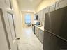 Kitchen with appliances with stainless steel finishes, gray cabinets, light marble finish flooring, light stone counters, and recessed lighting