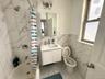Bathroom featuring shower / tub combo with curtain, vanity, tile walls, and light marble finish floors